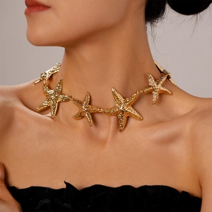 Close-up of golden starfish choker with hammered texture on elegant female model