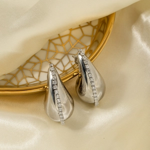 Silver teardrop earrings with 18K gold plating and cubic zirconia on silk background