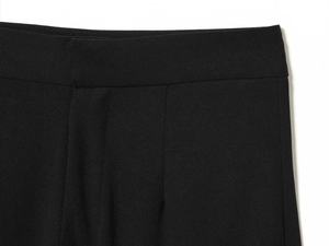 Detail shot of black high-waisted flared trousers featuring an invisible waist closure