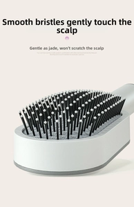 Close-up of rounded massage bristles and ergonomic handle on an ivory cushion hairbrush
