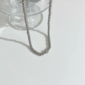 Detailed view of silver bead chain necklace with a sparkling round zircon centerpiece