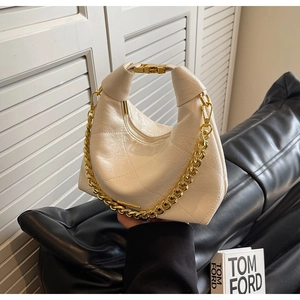 Detail of off-white quilted PU leather handbag with chunky gold chain and handle