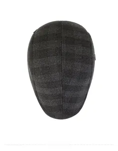 Top view of dark grey plaid flat cap showing thick textured fabric and neat stitching