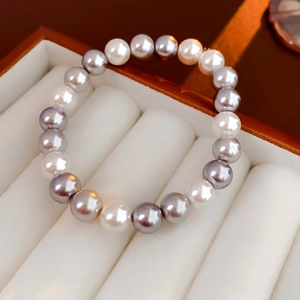 Macro shot of alternating white and lavender pearls on a velvet jewelry tray
