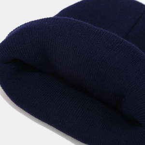 Close-up of navy blue knit texture and fine fiber detail on the warm MAMA winter beanie