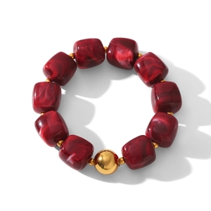 Close-up of vintage deep red marbled beads with a polished gold bead on a beaded bracelet