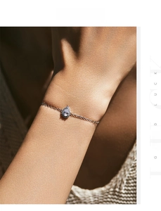 Détail d'un bracelet en argent avec pendentif diamant poire porté au poignet femme