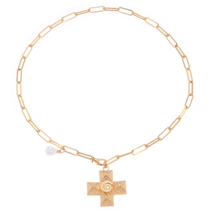 Detailed shot of golden paperclip chain necklace with textured swirl cross and pearl pendant