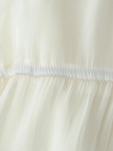 Detailed macro view of white chiffon fabric texture and vertical pleated seams on dress
