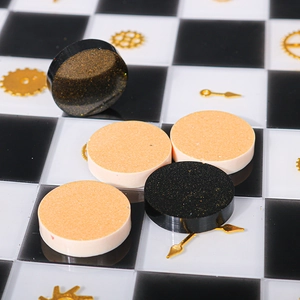 Macro shot of glitter resin chess pieces with gold gear accents on checkered board