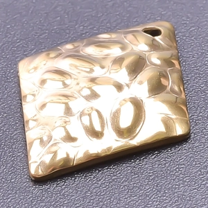 Macro shot of 18k gold plated stainless steel square pendant with hammered texture detail