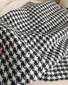 Detailed macro view of black and white houndstooth woven fabric texture on winter scarf