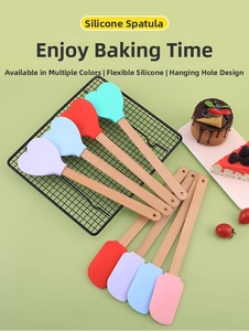 Macro shot of colorful silicone heart spatulas with wooden handles on a light green background