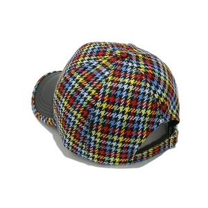 Detailed view of the colorful houndstooth fabric and black matte brim on a baseball cap