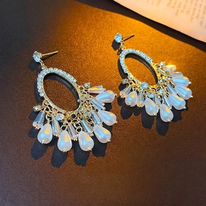Vintage gold tassel earrings with teardrop pearls and rhinestones on a textured base