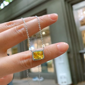 Elegant necklace with silver chain and square yellow gemstone pendant surrounded by small crystals