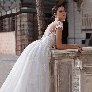 Elegant white lace V-neck wedding dress with floral embroidery and long cathedral train