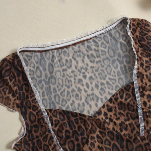 Detail of leopard print fabric with white lace mesh trim and V-neck stitching design