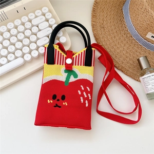 Detail showing the red strawberry-shaped knitted mini phone bag with its metal snap closure