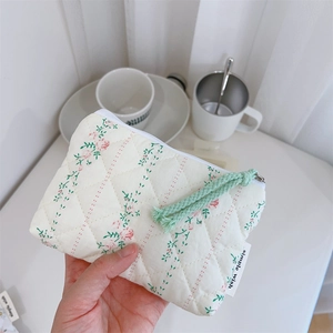 Détail du mini porte-monnaie matelassé à fleurs avec tirette de fermeture tissée