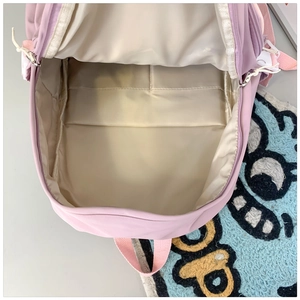 Detail of pink school backpack interior featuring beige lining and compartment divider