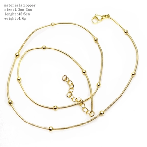 Detailed close-up of a 45cm gold-plated copper snake bone chain necklace with bead accents