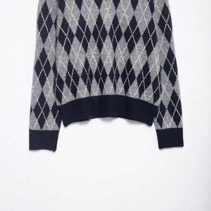 Classic argyle knit sweater with V-neck and ribbed cuffs in black white and grey tones