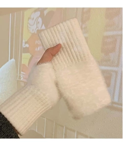 Close-up of white knit plush fingerless gloves with ribbed wrist cuffs for warmth