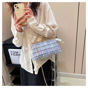 Detail of blue and purple tweed clutch with rhinestone trim and golden ring handle