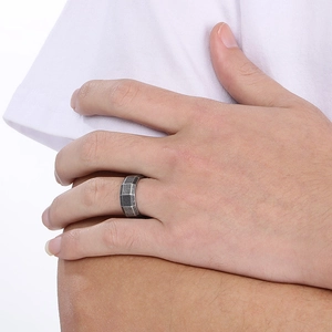Macro detail of men's 8mm brushed steel ring featuring a dark grey geometric checkerboard pattern