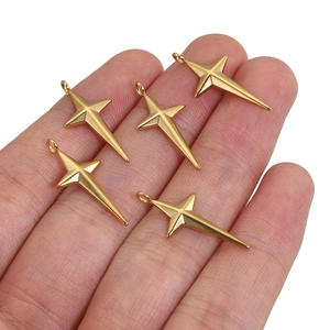 Golden 18k stainless steel star and cross pendants shown held in hand on white background