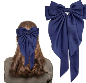 Detailed close-up of navy blue satin oversized bow hair clip with elegant long streamers