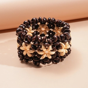 Vue détaillée du bracelet élastique tissé en perles de coco et bois aux tons contrastés
