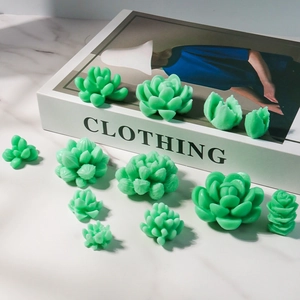 Gedetailleerde opstelling van diverse groene succulentkaarsen op marmeren ondergrond