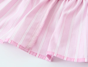 Detailed close-up of pink and white striped poplin fabric with neat hem stitching