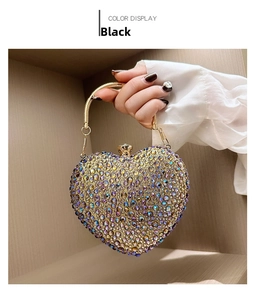 Detail of heart-shaped acrylic evening bag with sparkling rhinestones and gold handle