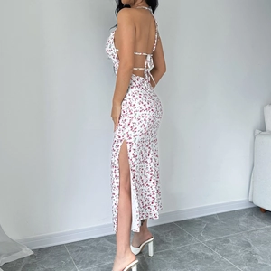 Detail view of the high slit design and floral pattern on the sleeveless midi dress