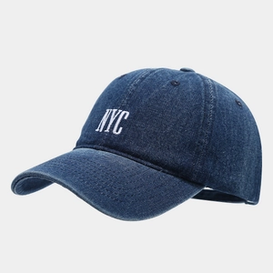 Close-up of the vintage blue denim texture and white NYC embroidery on the baseball cap