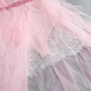 Detail of pink tiered mesh skirt featuring exquisite eyelash lace trim and pleated textures