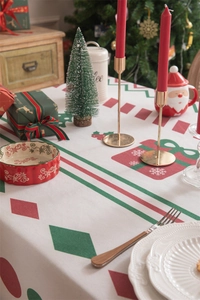 Close-up of festive Christmas tablecloth with red-green geometric floral print and tassels