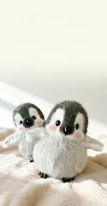 Nahaufnahme süßer Plüschpinguine mit rosa Wangen auf weißem Kunstpelzhintergrund