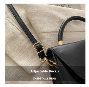 Détail de la boucle de réglage dorée sur la bandoulière en cuir PU noir mat du sac