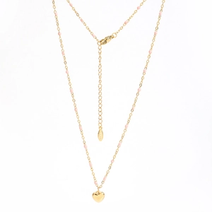 Collier en acier doré avec perles d'émail rose et pendentif cœur poli sur fond blanc