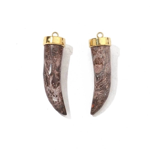 Macro detail of horn-shaped natural stone pendants with gold-plated stainless steel caps