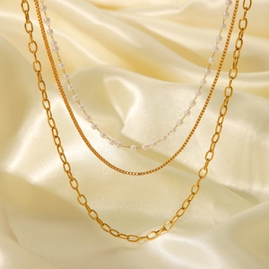 Detail view of triple-layered 18K gold stainless steel necklace with faux pearls
