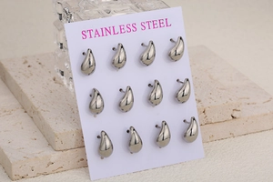 Macro detail of 12-piece polished stainless steel teardrop stud earrings set on display