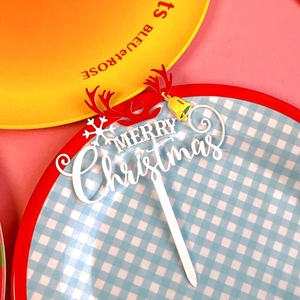 Macro detail of red and white double-layer acrylic Christmas cake topper with reindeer antlers