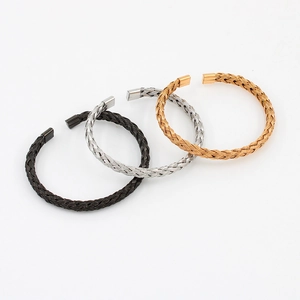 Close-up of woven stainless steel mesh bracelets in black, silver and golden finishes