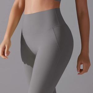 Detail showing high-waisted gray yoga leggings with reinforced stitching and elastic fabric