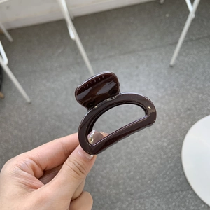 Close-up of glossy chocolate brown hair claw clip with smooth thick resin finish